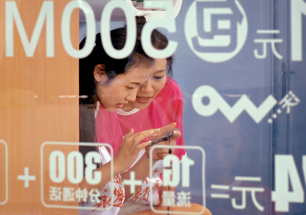 Two women surf the web on a mobile phone at an outlet of China Unicom in Nanjing, capital of Jiangsu province. AN XIN / FOR CHINA DAILY Two women surf the web on a mobile phone at an outlet of China Unicom in Nanjing, capital of Jiangsu province. AN XIN / FOR CHINA DAILY