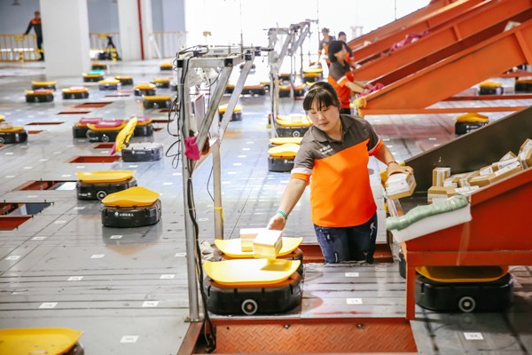 Employees of a delivery service company use robots to sort parcels in Yiwu, Zhejiang province. XINHUA Employees of a delivery service company use robots to sort parcels in Yiwu, Zhejiang province. XINHUA