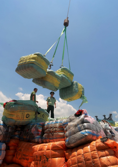 Border patrol officers handle parcels of used clothes that were smuggled from Hong Kong to the Chinese mainland in Shenzhen, Guangdong province, in June last year. A total of 549 metric tons of used clothes and canvas were seized. Long Yuxiang / For China Daily Border patrol officers handle parcels of used clothes that were smuggled from Hong Kong to the Chinese mainland in Shenzhen, Guangdong province, in June last year. A total of 549 metric tons of used clothes and canvas were seized. Long Yuxiang / For China Daily