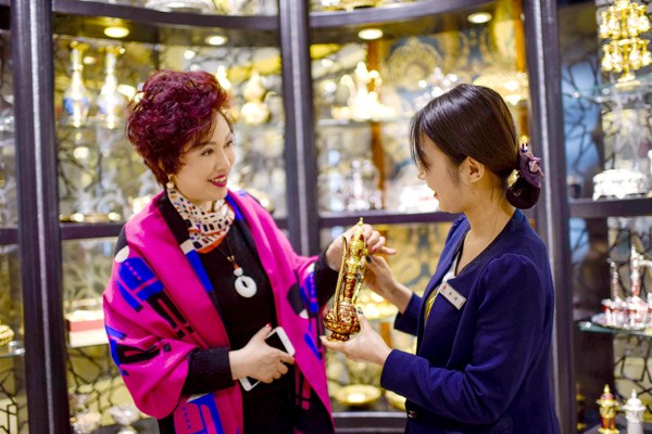 A tourist buys bronzeware made in Pakistan at the Grand Bazaar in Urumqi, capital of the Xinjiang Uygur autonomous region. XINHUA A tourist buys bronzeware made in Pakistan at the Grand Bazaar in Urumqi, capital of the Xinjiang Uygur autonomous region. XINHUA