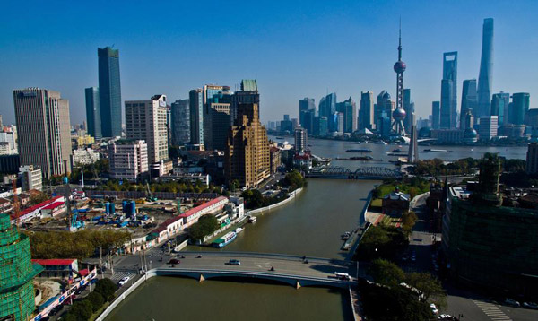 Photo taken on Nov. 27, 2015 shows the Baiyulan Plaza (L) of Puxi and buildings in Lujiazui of Pudong in Shanghai. (Photo/Xinhua)