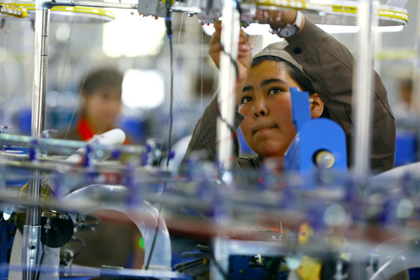 A worker fixes a thread on the production line at Huafu Top Dyed Melange Yarn Co in Aksu, a southern city in the Xinjiang Uygur autonomous region. Photo By Zhu Xingxin / China Daily A worker fixes a thread on the production line at Huafu Top Dyed Melange Yarn Co in Aksu, a southern city in the Xinjiang Uygur autonomous region. Photo By Zhu Xingxin / China Daily
