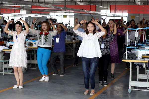 Workers dance during a break at a textile factory in Aksu. Photo By Zhu Xingxin / China Daily Workers dance during a break at a textile factory in Aksu. Photo By Zhu Xingxin / China Daily