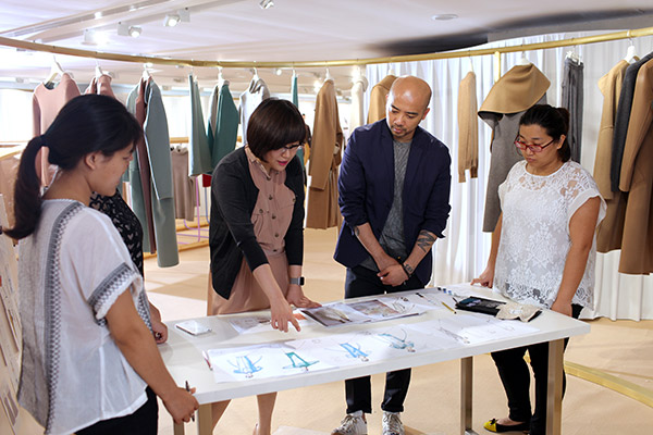 Wang Zhen (second from left), founder and president of 1436, discusses sketches for the styles of the new fashion season with other designers at the company's Beijing office in 2015. (Photo provided to China Daily) Wang Zhen (second from left), founder and president of 1436, discusses sketches for the styles of the new fashion season with other designers at the company's Beijing office in 2015. (Photo provided to China Daily)