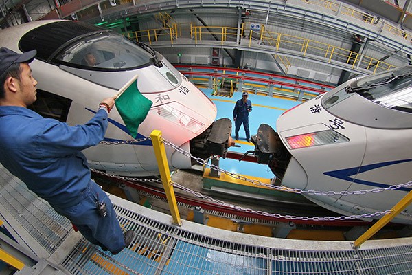 A worker guides two bullet trains to connect at a CRRC plant in Qingdao, Shandong province. CRRC hopes to take a 10 to 15 percent global market share by 2020. (Photo/China Daily) A worker guides two bullet trains to connect at a CRRC plant in Qingdao, Shandong province. CRRC hopes to take a 10 to 15 percent global market share by 2020. (Photo/China Daily)
