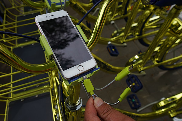Coolqi's new golden bikes, shown here in Beijing, have charging equipment for phones. (Photo/China Daily) Coolqi's new golden bikes, shown here in Beijing, have charging equipment for phones. (Photo/China Daily)