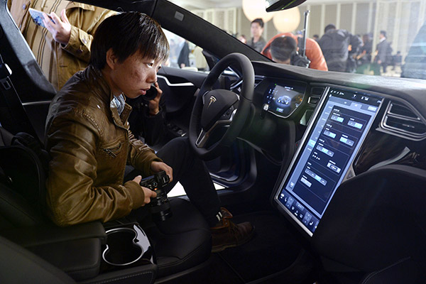 People experience Tesla's new product in 2015. The company has been developing autonomous cars in recent years. (Photo/Xinhua) People experience Tesla's new product in 2015. The company has been developing autonomous cars in recent years. (Photo/Xinhua)