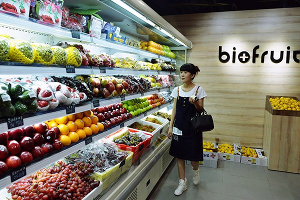 A woman selects fruits at an imported food store in Hangzhou, Zhejiang province. (Photo/China Daily) A woman selects fruits at an imported food store in Hangzhou, Zhejiang province. (Photo/China Daily)
