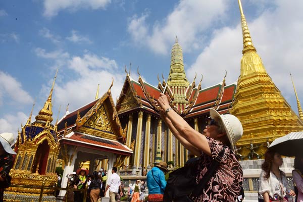 A Chinese tourist takes a photo at a Buddhist temple in Bangkok. (Photo/China Daily) A Chinese tourist takes a photo at a Buddhist temple in Bangkok. (Photo/China Daily)