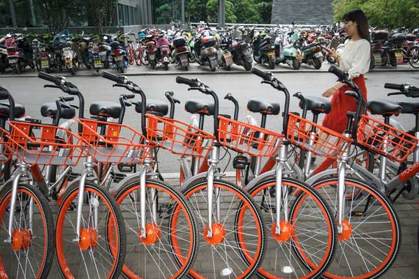 A woman walks past Mobikes lined up in a street in Zhengzhou, capital of Henan province. (Photo/China Daily) A woman walks past Mobikes lined up in a street in Zhengzhou, capital of Henan province. (Photo/China Daily)