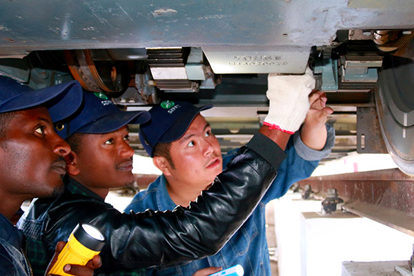 Qiu An, a trainer at Shenzhen Metro, shares rail vehicle maintenance tips with two local colleagues in Addis Ababa, the capital of Ethiopia. (Photo provided to China Daily) Qiu An, a trainer at Shenzhen Metro, shares rail vehicle maintenance tips with two local colleagues in Addis Ababa, the capital of Ethiopia. (Photo provided to China Daily)