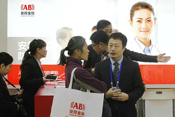 Anbang sales staff explain the insurer's products to visitors at the Beijing Internatonal Investment and Wealth Management Expo. (Photo/China Daily) Anbang sales staff explain the insurer's products to visitors at the Beijing Internatonal Investment and Wealth Management Expo. (Photo/China Daily)