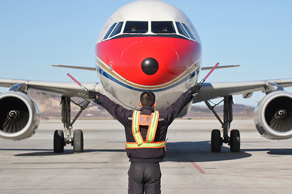 A ground crew member leads a China Eastern Airlines cargo plane to land at Yantai Penglai International Airport in Shandong province. (Photo/China Daily) A ground crew member leads a China Eastern Airlines cargo plane to land at Yantai Penglai International Airport in Shandong province. (Photo/China Daily)