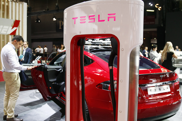 A Tesla electric charger is displayed next to a Telsa model S car during an auto show in Paris, France. (Photo provided to CHINA DAILY) A Tesla electric charger is displayed next to a Telsa model S car during an auto show in Paris, France. (Photo provided to CHINA DAILY)