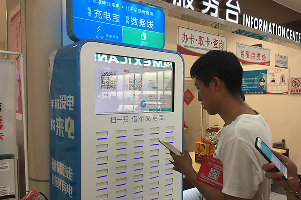 A customer tries a shared power bank at a shopping center in Jinan, Shandong province. (Photo/China Daily) A customer tries a shared power bank at a shopping center in Jinan, Shandong province. (Photo/China Daily)