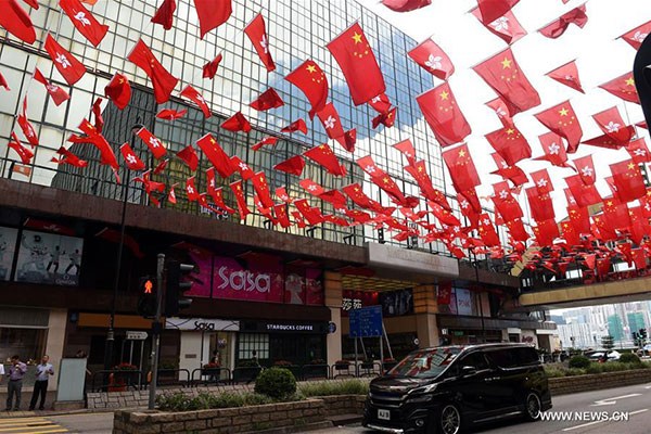 A car drives under Chinese national flags and flags of Hong Kong Special Administrative Region in Tsim Sha Tsui of Hong Kong, China, June 27, 2017. (Photo/Xinhua) A car drives under Chinese national flags and flags of Hong Kong Special Administrative Region in Tsim Sha Tsui of Hong Kong, China, June 27, 2017. (Photo/Xinhua)