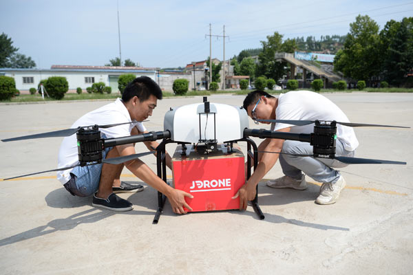 Staff from JD.com Inc attach a package to a drone in Xi'an, capital of Shaanxi province. (Photo/Xinhua) Staff from JD.com Inc attach a package to a drone in Xi'an, capital of Shaanxi province. (Photo/Xinhua)