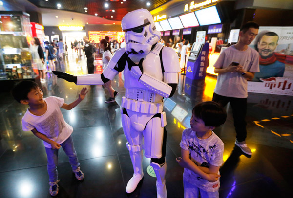 A man dressed up as a robot plays around with two kids at a Wanda cinema in Qingdao, Shandong province. (Photo by He Haier/For China Daily) A man dressed up as a robot plays around with two kids at a Wanda cinema in Qingdao, Shandong province. (Photo by He Haier/For China Daily)