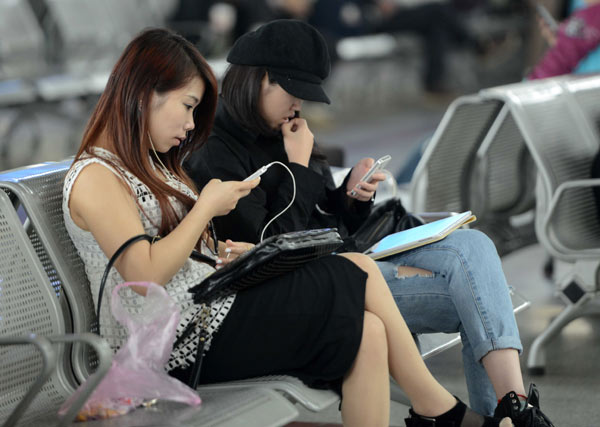 Passengers at Jiangxi railway station read e-novels on their mobile phones while waiting for their train to arrive. (Photo by Hu Guolin/For China Daily) Passengers at Jiangxi railway station read e-novels on their mobile phones while waiting for their train to arrive. (Photo by Hu Guolin/For China Daily)