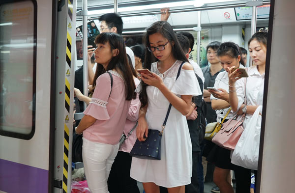 Passengers read e-books on mobile devices on a subway train in Guangzhou, Guangdong province. (Photo by Zhang Yang/For China Daily) Passengers read e-books on mobile devices on a subway train in Guangzhou, Guangdong province. (Photo by Zhang Yang/For China Daily)