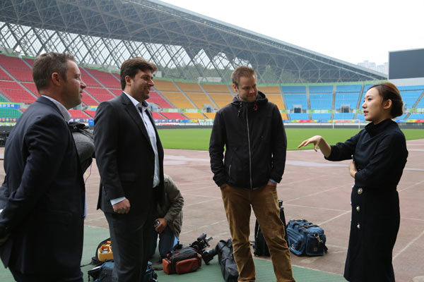 Wen Xiaoting, chairwoman of the soccer club Guizhou Hengfeng Zhicheng, explains her brand promotion idea during chat with three German Channel 2 television staff in a soccer stadium in Guizhou province. (Photo by Yang Jun/For China Daily) Wen Xiaoting, chairwoman of the soccer club Guizhou Hengfeng Zhicheng, explains her brand promotion idea during chat with three German Channel 2 television staff in a soccer stadium in Guizhou province. (Photo by Yang Jun/For China Daily)