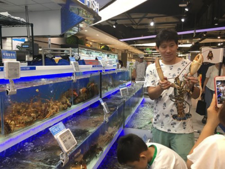 A customer has a picture taken with a lobster at the Hema store in Chaoyang, Beijing on Thursday. (Photo: Dong Feng/GT) A customer has a picture taken with a lobster at the Hema store in Chaoyang, Beijing on Thursday. (Photo: Dong Feng/GT)