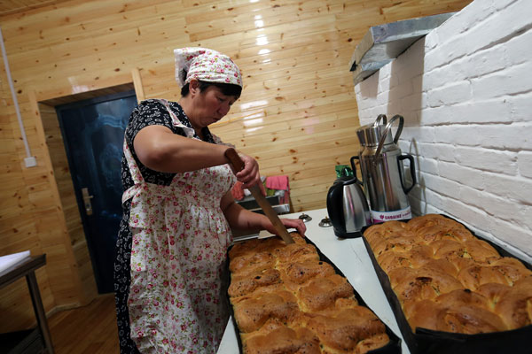 A woman prepares food for Russian tourists in a folk village in Inner Mongolia. (Photo by Wang Zhuangfei/For China Daily) A woman prepares food for Russian tourists in a folk village in Inner Mongolia. (Photo by Wang Zhuangfei/For China Daily)