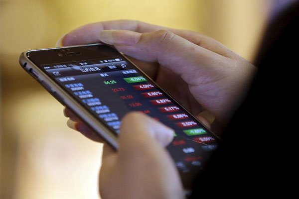 A man checks share prices on his mobile phone while waiting for his coffee at a Starbucks branch in Beijing July 16, 2015.(Photo/Agencies) A man checks share prices on his mobile phone while waiting for his coffee at a Starbucks branch in Beijing July 16, 2015.(Photo/Agencies)