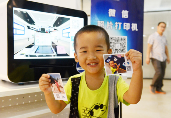 A boy is impressed with the images produced by a WeChat photo printer. A boy is impressed with the images produced by a WeChat photo printer.