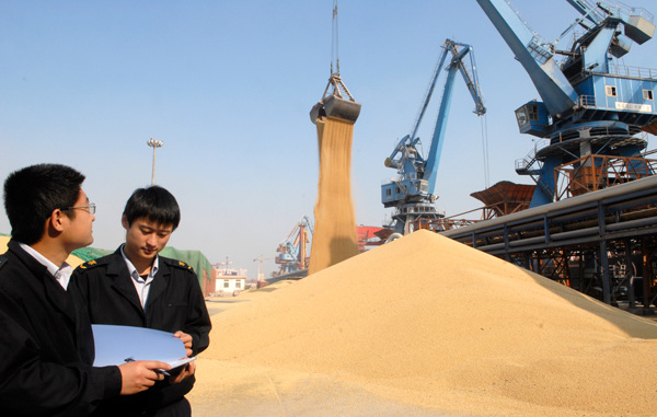 Two officials from Shandong Inspection and Quarantine Bureau check imported soybeans at Rizhao port, Shandong province. (Zhu Yuanli/for China Daily) Two officials from Shandong Inspection and Quarantine Bureau check imported soybeans at Rizhao port, Shandong province. (Zhu Yuanli/for China Daily)