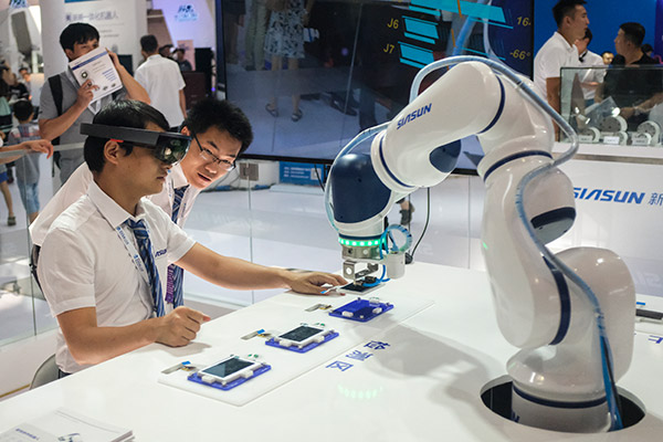 Employees of Siasun Robot & Automation Co use a robot and special eye gear to demonstrate phone repairs during the World Robot Conference held in Beijing, Aug 23, 2017. (Photo/China Daily by Akash Ghai) Employees of Siasun Robot & Automation Co use a robot and special eye gear to demonstrate phone repairs during the World Robot Conference held in Beijing, Aug 23, 2017. (Photo/China Daily by Akash Ghai)