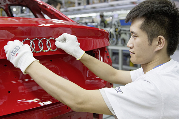 A worker checks up the logo of a car at one of Audi's production lines. (Photo provided to China Daily) A worker checks up the logo of a car at one of Audi's production lines. (Photo provided to China Daily)
