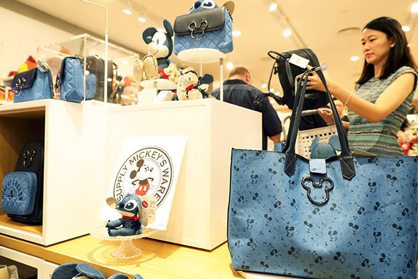Visitors examine products at a Disney shop in Shanghai, which opened last week. (Photo/China News Service by Tang Yanjun) Visitors examine products at a Disney shop in Shanghai, which opened last week. (Photo/China News Service by Tang Yanjun)