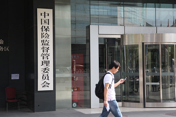 A visitor checks his cellphone at the gate of the China Insurance Regulatory Commission. (Photo: Liu Yuanrui/China Daily) A visitor checks his cellphone at the gate of the China Insurance Regulatory Commission. (Photo: Liu Yuanrui/China Daily)