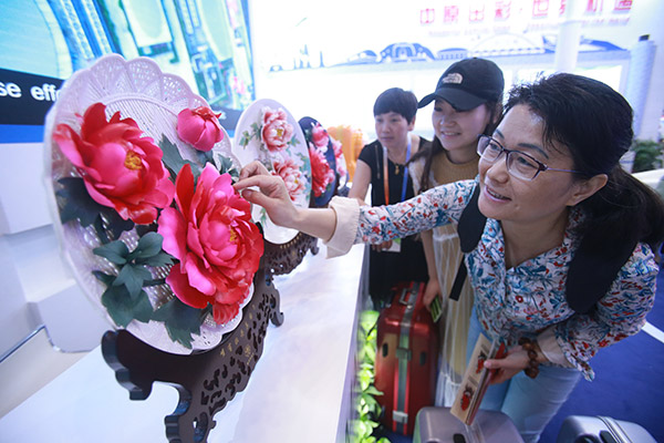 Visitors examine porcelain products made in Luoyang, Henan province, during an international fair for trade in services held in Beijing. (Chen Xiaogen/for China Daily) Visitors examine porcelain products made in Luoyang, Henan province, during an international fair for trade in services held in Beijing. (Chen Xiaogen/for China Daily)