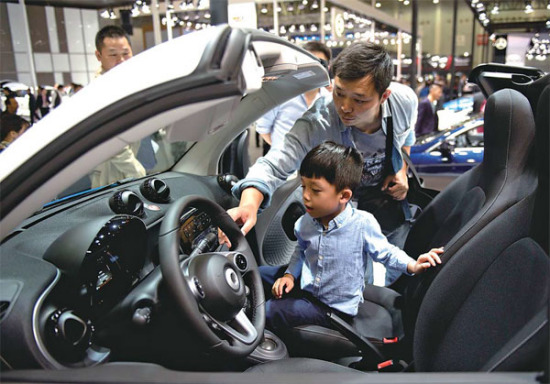 A visitor and his child try out a new car at an auto show in Wuhan, Hubei province. (Photo/Xinhua) A visitor and his child try out a new car at an auto show in Wuhan, Hubei province. (Photo/Xinhua)