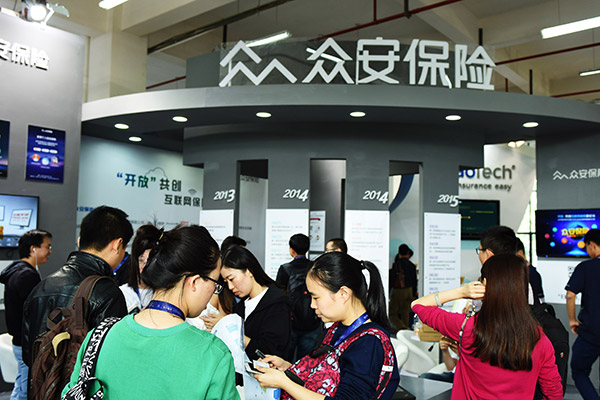 Visitors pass the exhibition stand of ZhongAn Online Property and Casualty Insurance Co Ltd in Hangzhou. (Long Wei/for China Daily) Visitors pass the exhibition stand of ZhongAn Online Property and Casualty Insurance Co Ltd in Hangzhou. (Long Wei/for China Daily)