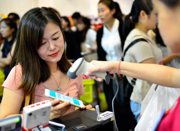 A woman pays via Alipay at a shop in Singapore. (Photo/Xinhua) A woman pays via Alipay at a shop in Singapore. (Photo/Xinhua)