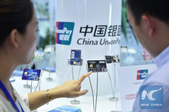 A staff member (L) of China UnionPay introduces a new type of bank card with visualized information function at an exhibition in Beijing, capital of China, June 1, 2015. (Xinhua/Li Xin) A staff member (L) of China UnionPay introduces a new type of bank card with visualized information function at an exhibition in Beijing, capital of China, June 1, 2015. (Xinhua/Li Xin)