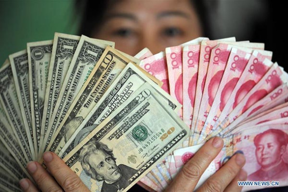 A residents shows China's yuan and US dollar banknotes in Qionghai, South China's Hainan province, Jan 7, 2016. (Photo/Xinhua) A residents shows China's yuan and US dollar banknotes in Qionghai, South China's Hainan province, Jan 7, 2016. (Photo/Xinhua)