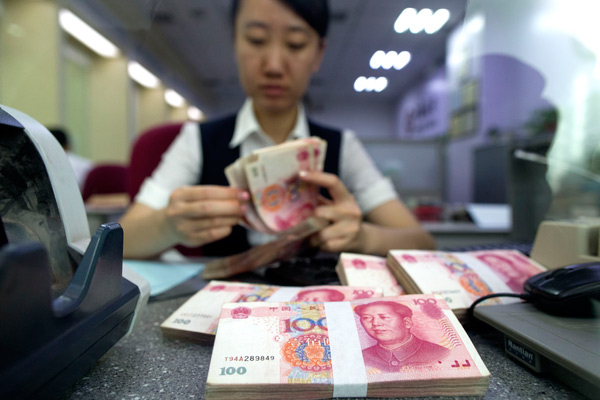 A staff member of a bank in Taiyuan, Shanxi province, counts cash at a customer-facing counter. (Photo by Zhang Yun/For China Daily) A staff member of a bank in Taiyuan, Shanxi province, counts cash at a customer-facing counter. (Photo by Zhang Yun/For China Daily)