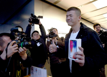 A customer flaunts his iPhone X bought from an Apple outlet in Beijing, Nov 3, 2017. The US firm posted strong revenue growth in China during the third quarter of this year. (Photo provided to China Daily) A customer flaunts his iPhone X bought from an Apple outlet in Beijing, Nov 3, 2017. The US firm posted strong revenue growth in China during the third quarter of this year. (Photo provided to China Daily)