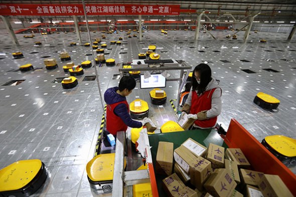 Staff work alongside robots to help sort out packages at a logistics company in Tianjin. (ZHU XINGXIN/CHINA DAILY) Staff work alongside robots to help sort out packages at a logistics company in Tianjin. (ZHU XINGXIN/CHINA DAILY)