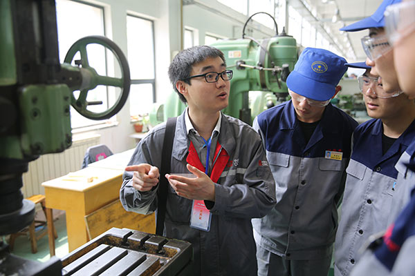 A technician of CRRC Qingdao Sifang Co Ltd, a high-speed train manufacturer, gives instructions to students at a vocational school in Shandong Province. (Photo/China Daily) A technician of CRRC Qingdao Sifang Co Ltd, a high-speed train manufacturer, gives instructions to students at a vocational school in Shandong Province. (Photo/China Daily)