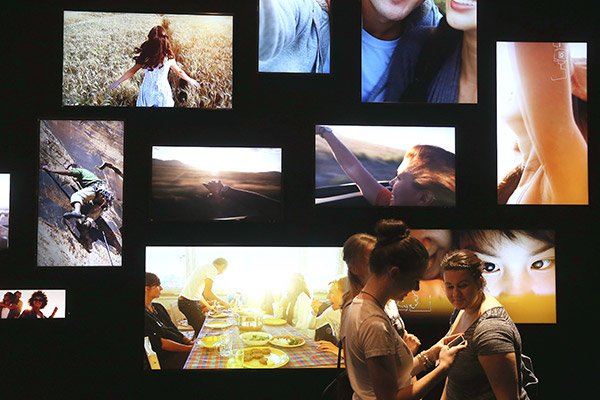 People walk past LED television monitors at the Toshiba stand at a trade fair in Berlin, Germany. (Photo provided to China Daily)