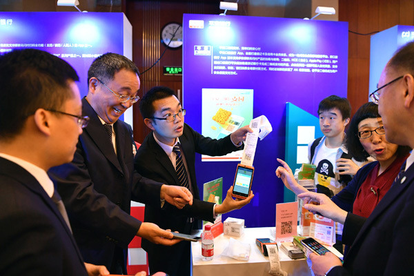 Employees introduce mobile payment application services during a promotional event in Beijing. (Photo/Xinhua) Employees introduce mobile payment application services during a promotional event in Beijing. (Photo/Xinhua)