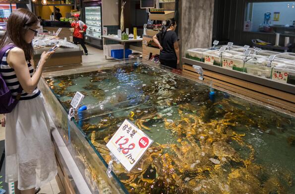 A customer chooses seafood at a supermarket of Bailian Group in Shanghai. The company is setting up a commodity trading platform targeting sales of a trillion yuan. (Photo by Wang Gang/For China Daily) A customer chooses seafood at a supermarket of Bailian Group in Shanghai. The company is setting up a commodity trading platform targeting sales of a trillion yuan. (Photo by Wang Gang/For China Daily)