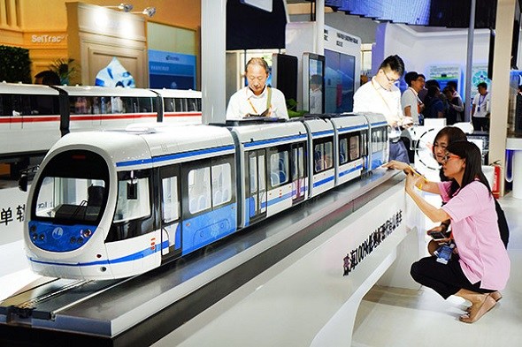 Visitors look at the latest models of urban rail trains shown at the International Urban Rail Exhibition in Beijing.(Photo by Guo Junfeng/Xinhua)