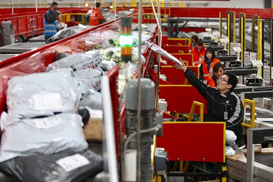 Workers of SF Express sort packages at an outlet of the company in Beijing. (Photo/China Daily by Zhu Xingxin) Workers of SF Express sort packages at an outlet of the company in Beijing. (Photo/China Daily by Zhu Xingxin)