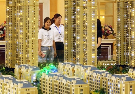 A saleswoman (center) talks with customers at a real estate sales office in Huaian, Jiangsu province. (Photo:China News Service/Zhou Changguo) A saleswoman (center) talks with customers at a real estate sales office in Huaian, Jiangsu province. (Photo:China News Service/Zhou Changguo)